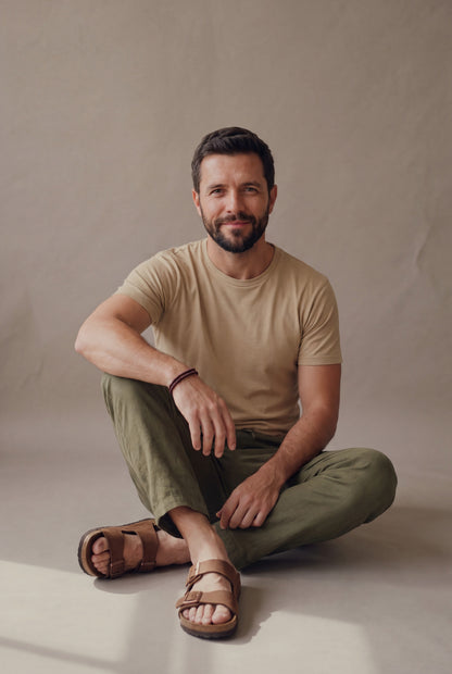 Pantalón de descanso en lino verde militar para hombre, modelo sentado en el piso del estudio, Luck & Load