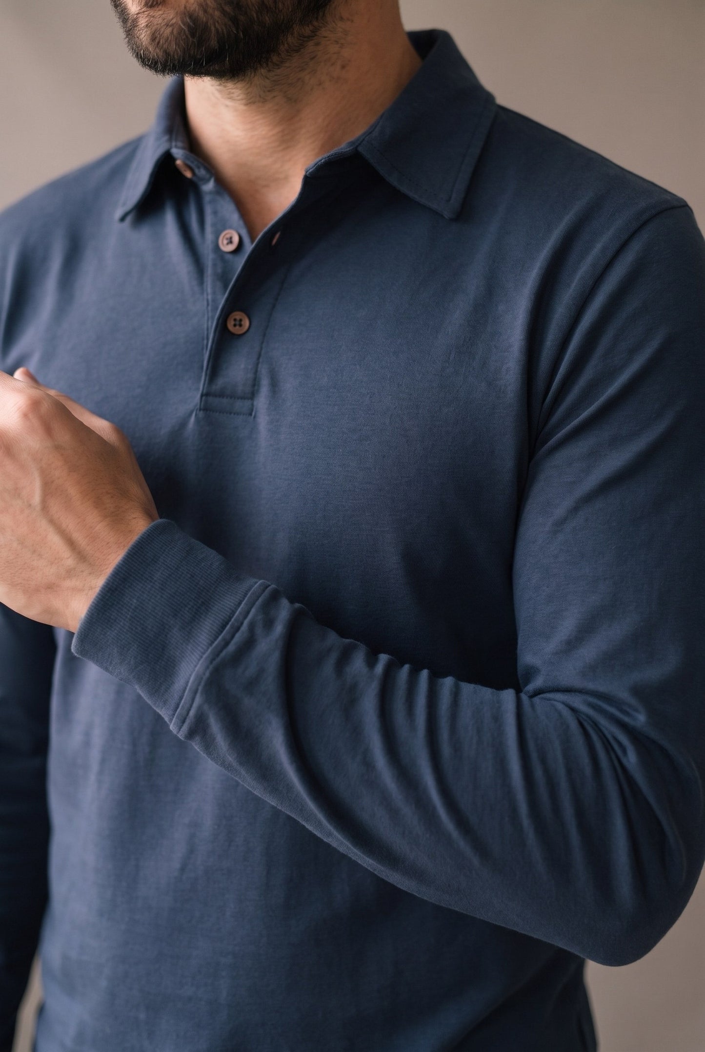 Detalle del cuello, los botones de corozo y el puño del polo de manga larga azul marino de Luck & Load.