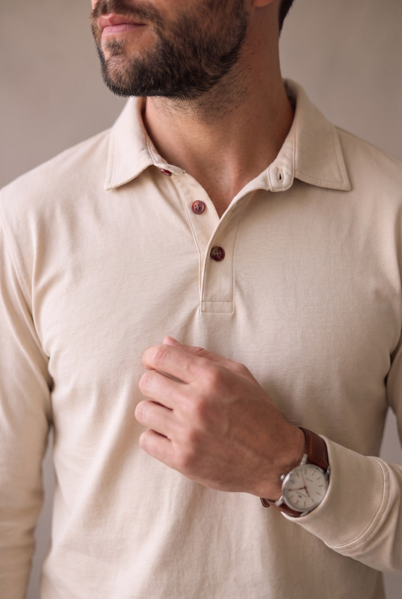 Detalle del cuello, los botones de corozo y el puño del polo de manga larga beige de Luck & Load.